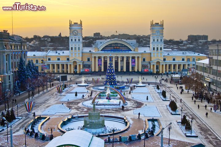 Immagine Decorazioni natalizie alla stazione ferroviaria di Kharkiv, Ucraina. Albero di Natale e addobbi impreziosiscono la piazza della stazione a Kharkiv imbiancata da una spolverata di soffice neve 