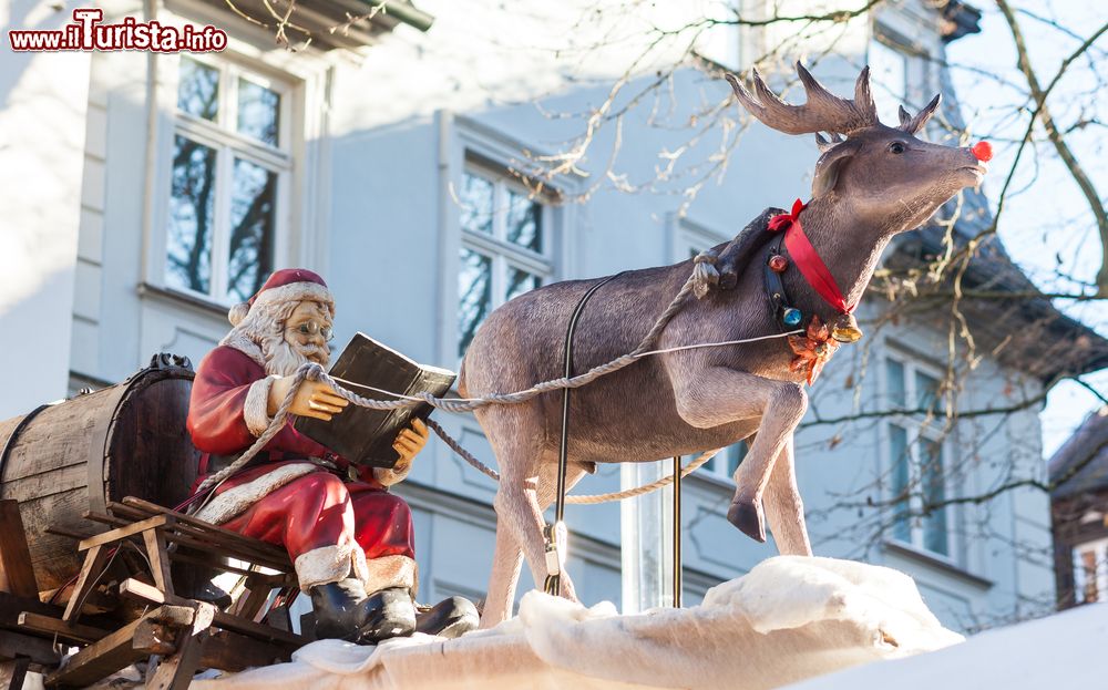 Immagine Decorazioni natalizie sul tetto di uno stand del mercato a Bamberga, Germania: Babbo Natale con slitta e renna.