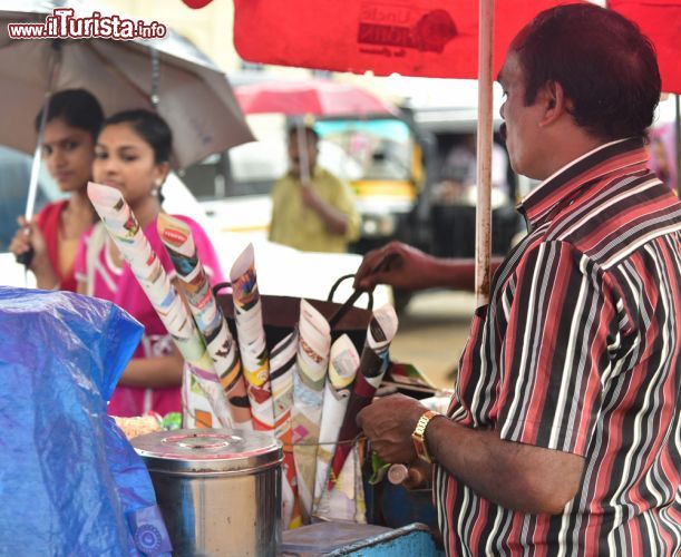 Immagine Due ragazze acquistano noccioline arrostite da un venditore ambulante a Trivandrum, India - © Ajayptp / Shutterstock.com