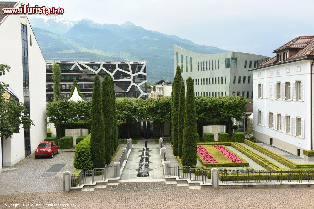 Immagine Edifici in centro a Vaduz, Lichtenstein, con un bel giardino e aiuole - © Bumble Dee / Shutterstock.com