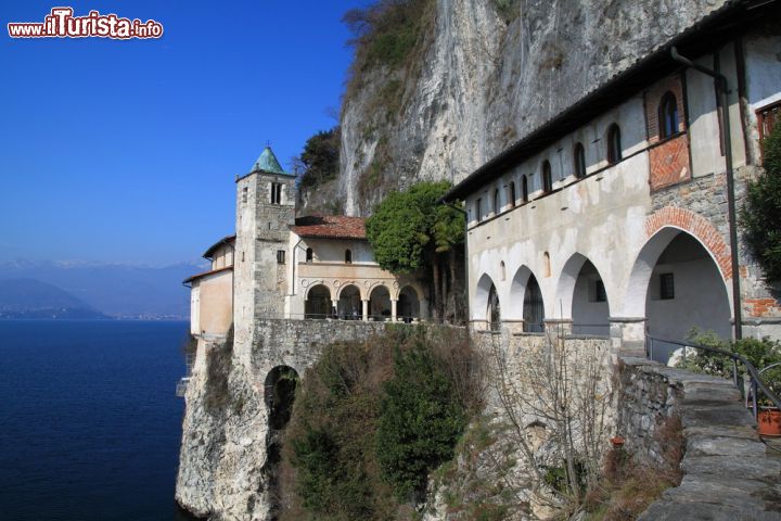 Immagine Eremo di Santa Caterina a Leggiuno nei pressi di Laveno Mombello, Lombardia. Questo monastero a strapiombo sulla sponda orientale del Lago Maggiore sorge nel territorio di Leggiuno, vicino a Laveno Mombello. Questo edificio religioso avrebbe le sue origini nel XII° secolo. La facciata si presenta con un bel porticato in stile rinascimentale contraddistinto da 4 archi a tutto sesto; sulla sinistra si eleva il campanile del XIV° secolo - © Eisblumen / Shutterstock.com