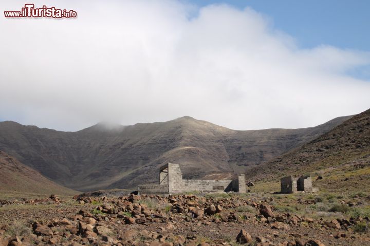 Immagine Vista del Faro de punta Jandia a Fuerteventura - Proprio in questo meraviglioso contrasto dove le ripide discese abbracciano il più dolce terreno pianeggiante, vi è una menzione. Nel 1987 fu dichiarato Parco Naturale e dando un'occhiata all'immagine non è difficile immaginarne il motivo. Oltre all'interesse archeologico, qui spiccano anche cultura e tradizione, in un unicum di identità di sicuro vanto per tutte le Isole Canarie.