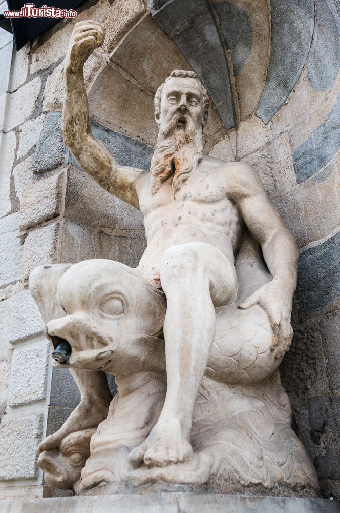 Immagine Fontana con scultura a Besancon, Francia: la statua rappresenta un vecchio uomo seduto su un pesce.