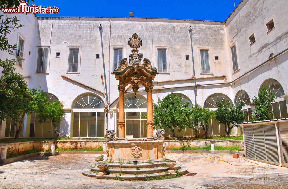 Immagine La fontana nel chiostro della Chiesa di San Francesco a Fasano, Puglia, Italia. Di epoca barocca questo pozzo centrale è decorato con volute floreali e mascheroni. Si ritiene sia opera dell'artista Vanvitelli.