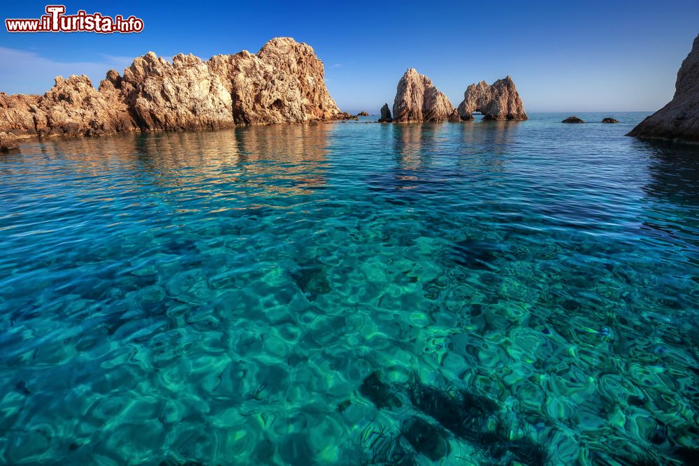 Immagine Formazioni rocciose lungo la costa dell'isola di Antiparos (Cicladi) con acqua color smeraldo.
