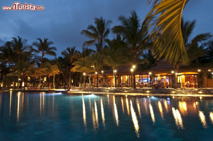 Immagine Foto notturna di un resort a Grand Baie, Mauritius - Grazie ai cambiamenti avvenuti nel corso degli anni '70, Grand Baie si è trasformato da un povero villaggio di pescatori in un importante centro turistico. Resort e strutture di lusso attirano turisti da ogni parte del mondo: in questa immagine, un suggestivo bar sotto le stelle dove sorseggiare una bibita vicino alla piscina © tony740607 / Shutterstock.com