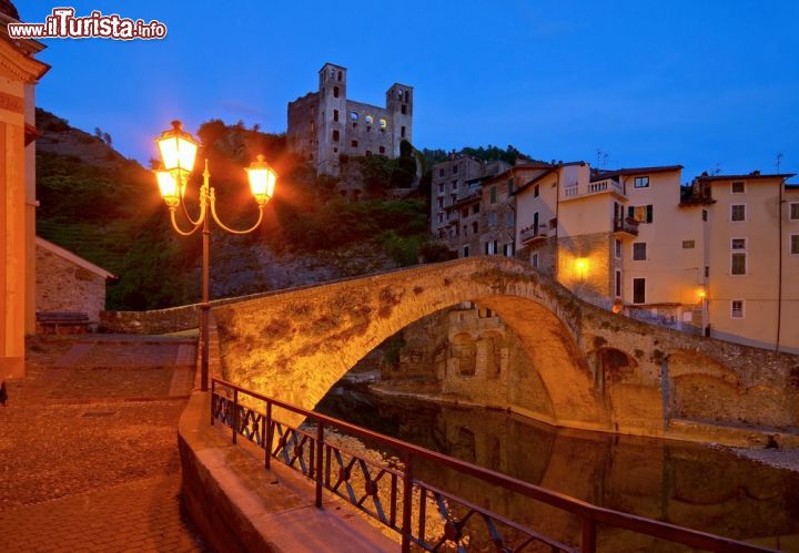 Immagine Dolceacqua di notte, Liguria, Italia - Con le luci del tramonto questo grazioso villaggio medievale della Val Nervia, lungo l'omonimo torrente, regala a chi lo visita un'atmosfera ancora più suggestiva © LianeM / Shutterstock.com