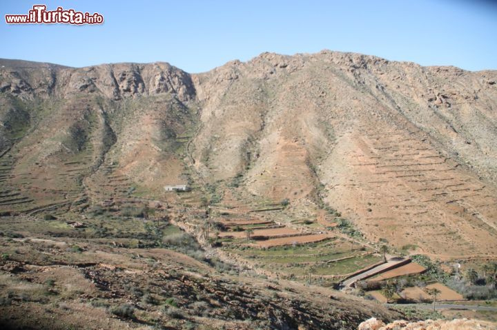 Immagine Le generose montagne di Pajara, Betancuria (Fuerteventura/Isole Canarie) - Come si vede dall'immagine non è difficile immaginare cosa succede quando ci si trova al cospetto di questo spettacolo. Ovviamente moltissima l'ammirazione per un contesto così pittoresco che unisce la natura alla città, ma anche molto stupore per un segno caratteristico così evidente da essere comunque rimasto tale nel corso del tempo.