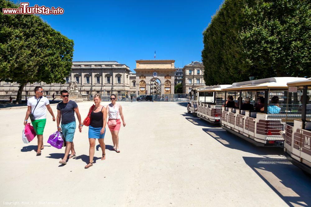 Immagine Gente a passeggio nella suggestiva Promenade du Peyrou a Montpellier (Francia) con a fianco il trenino turistico  - © Mike_O / Shutterstock.com