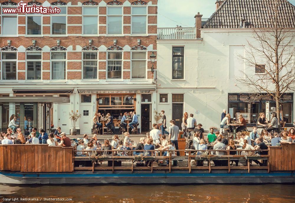 Immagine Gente pranza su una barca-caffé all'aperto lungo i canali di Den Haag, Olanda - © Radiokafka / Shutterstock.com