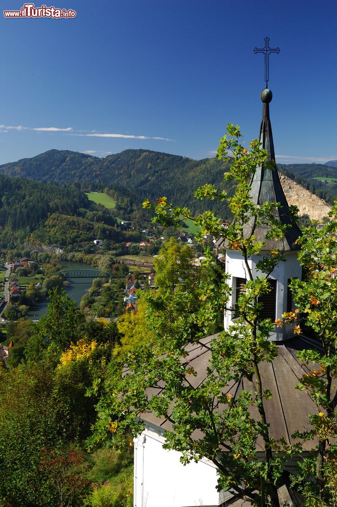 Immagine Una graziosa chiesa cattolica a Leoben, Austria. Sullo sfondo uno dei ponti cittadini che attraversa il fiume Mura.