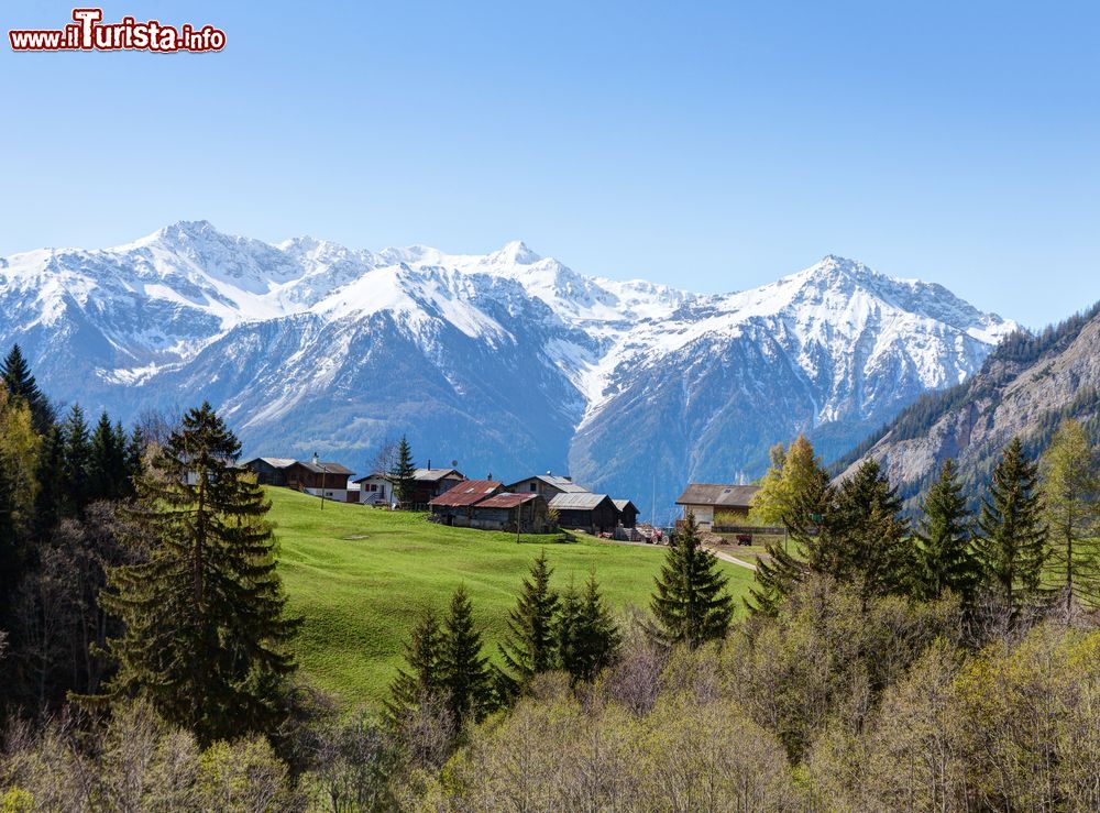 Immagine Un gruppo di case alla luce mattutina della primavera vicino a Leukerbad, Svizzera.