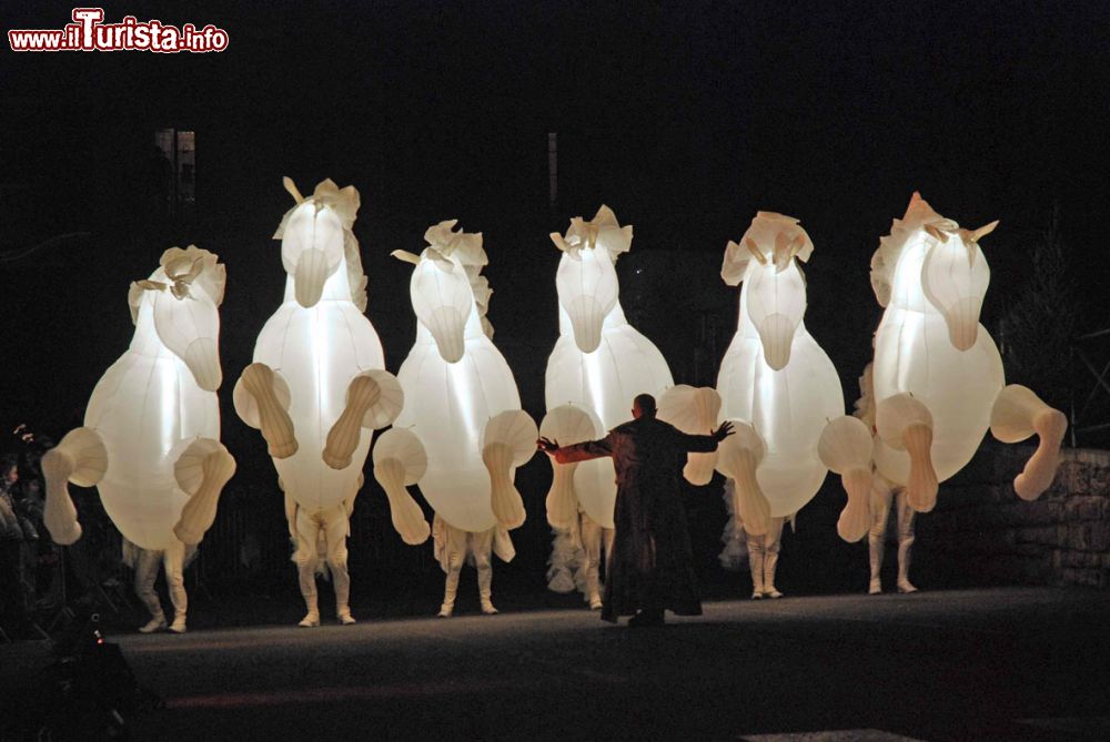 Immagine I Cavalli Luminosi sul palco della Disfida di Barletta, Puglia. Alti più di 4 metri, questi enormi cavalli, leggeri e sinuosi, portano in scena una suggestiva danza in occasione della rievocazione della Disfida di Barletta, piece di teatro popolare.