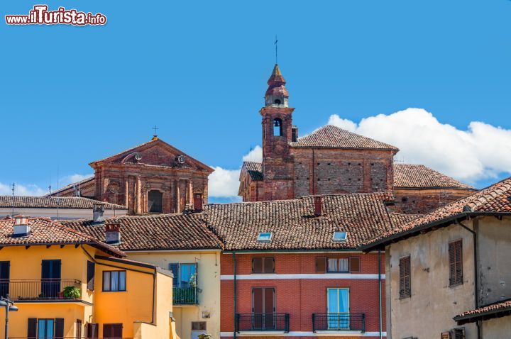 Immagine Il campanile della chiesa cattolica di La Morra, Cuneo, Piemonte. Un grazioso scorcio fotografico della torre campanaria del paese che si innalza fra le antiche case dalle facciate colorate