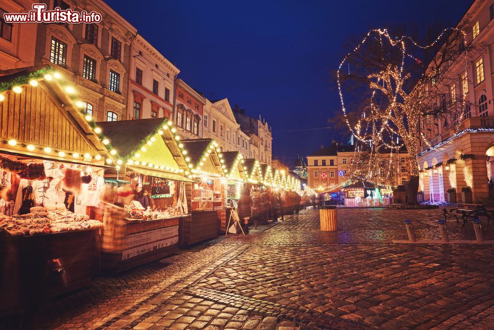 Immagine Il centro di Lviv by night durante il Natale, Ucraina. Le bancarelle in legno con prodotti artigianali e souvenir, illuminate dalle luminarie, sono un classico del periodo dell'Avvento.