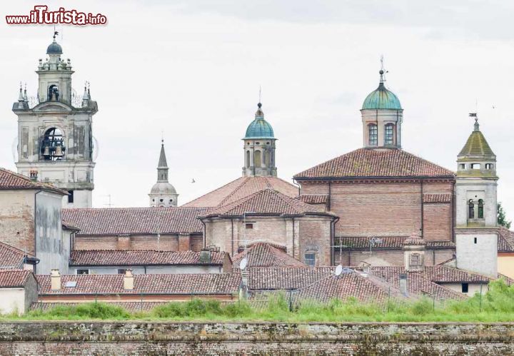 Immagine Le nuvole sui tetti di Sabbioneta - la città di Sabbioneta fu edificata secondo i principi della città ideale nel XVI secolo per volere del duca Vespasiano Gonzaga. La città fu inoltre pensata come baluardo difensivo in quanto la sua posizione nel cuore della Pianura Padana era a dir poco strategica e venne quindi dotata di un'imponente cinta muraria che possiamo scorgere nella fotografia. - © PHB.cz (Richard Semik) / Shutterstock.com