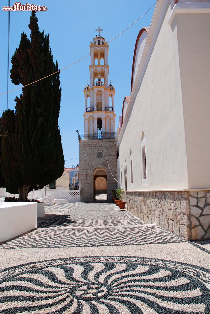 Immagine Il cortile con mosaici in ciottoli e la torre campanaria della chiesa di Agios Nikolas, isola di Chalki (Grecia). La torre campanaria è la più alta nelle isole del Dodecaneso.
