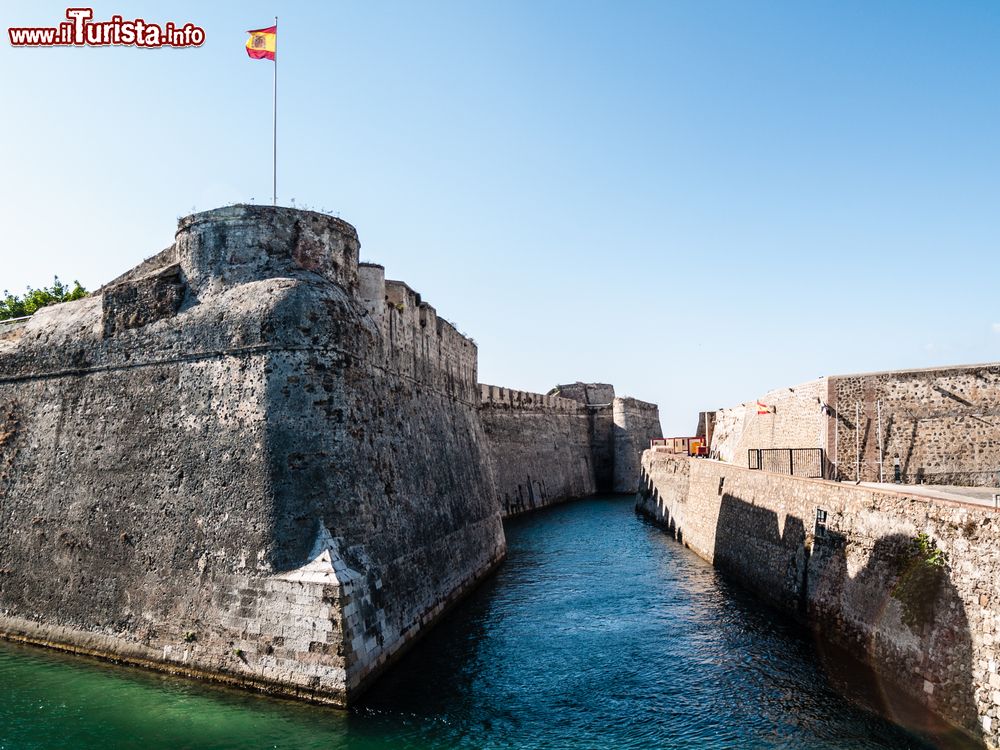 Immagine Il fossato navigabile del castello di Ceuta, Spagna. Su entrambi i lati delle mura sventolano le bandiere spagnole.