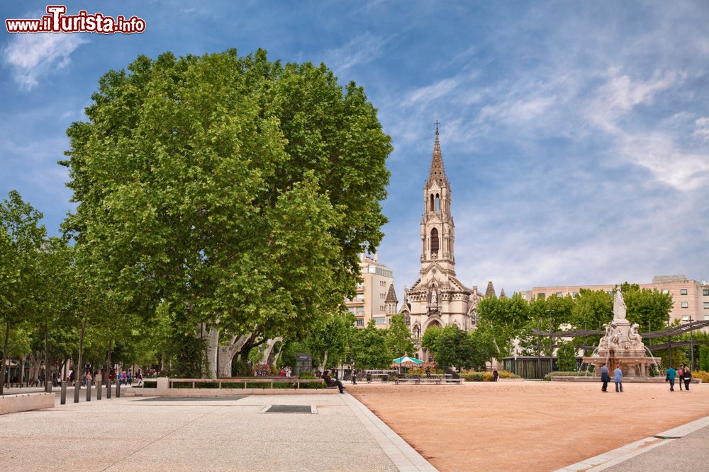 Immagine Il giardino di piazza Esplanade Charles-de-Gaulle a Nimes (Francia) con l'antica fontana Pradier e la chiesa di Santa Perpetua in stile neogotico.