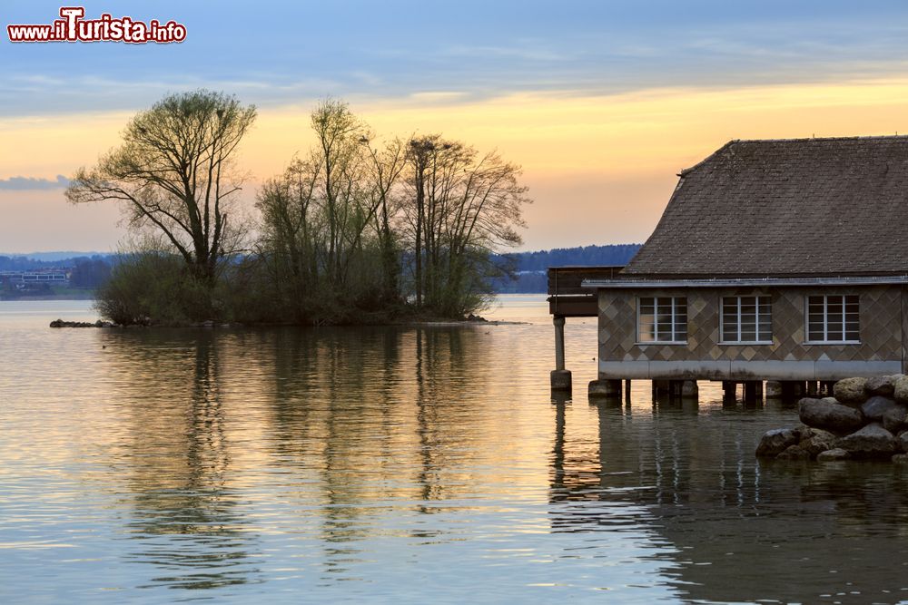 Immagine Il lago di Zugo visto al tramonto in primavera, Svizzera. Una pittoresca casa residenziale costruita sull'acqua.