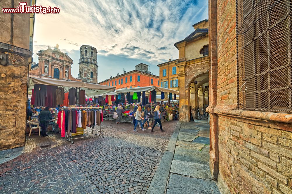 Immagine Il mercato settimanale in Piazza Piccola a Reggio Emilia, Emilia Romagna. Bancarelle di vario genere si trovano nel mercato organizzato settimanalmente in Piazza San Prospero (attuale nome di Piazza Piccola). Ha forma rettangolare con tre lati porticati.