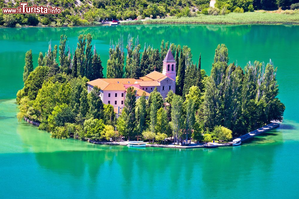 Immagine Il monastero dell'isola di Visovac nel Parco Nazionale di Krka, Dalmazia, Croazia. Quest'isolotto che sorge nelle acque del lago lungo il corso della Cherca ospita un convento francescano che risale al 1445 dedicato alla Madonna delle Grazie.