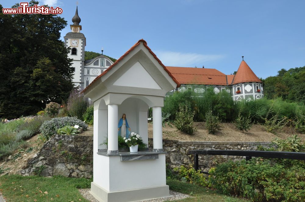 Immagine Una piccola edicola e sullo sfondo Il monastero di Olimje (Olimia) in Slovenia