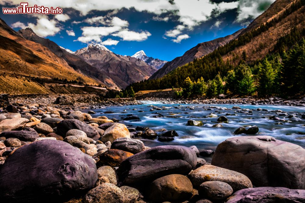 Immagine Il villaggio di Chitkul nel distretto di Kinnaur, Himachal Pradesh, India. Ultimo centro abitato vicino al confine indo-cinese, Chitkul durante l'inverno rimane quasi completamente ricoperto di neve e i suoi abitanti si trasferiscono nelle zone più meridionali dell'Himachal. Questa imamgine di un fiume nei pressi del villaggio è forse la fotografia più scattata dai turisti e dai viaggiatori che si recano fin qui in visita.