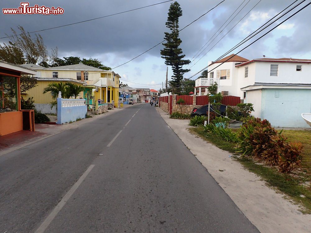 Immagine In viaggio lungo King's Highway road a Bailey Town, Bimini, arcipelago delle Bahamas. Ai lati della strada le tipiche casette colorate.