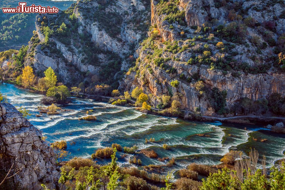 Immagine Increspature al calar del sole sulle acque delle cascate Roski Slap, Krka, Croazia. Il canyon in questa parte del fiume si allarga e prende la forma di un imbuto.