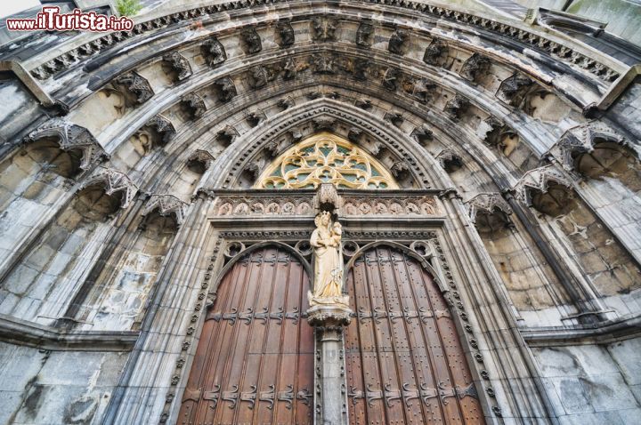 Immagine Un particolare dell'ingresso della Collegiata di Notre-Dame a Dinant. L'edificio fu costruito nel XIII secolo in sostituzione della precedente chiesa distrutta dalla caduta di un masso dalla parete rocciosa alle sue spalle - foto © skyfish / Shutterstock.com