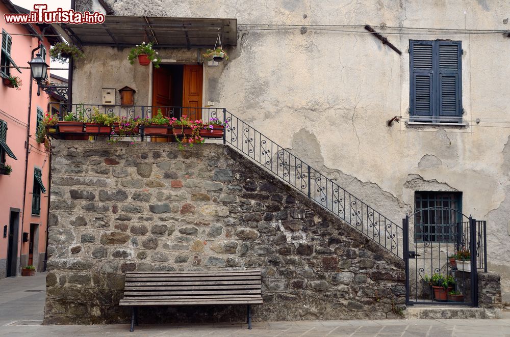 Immagine L'ingresso di una vecchia casa nel centro storico di Brugnato, La Spezia, Italia. Bella la ringhiera in ferro che delimita la scalinata per accedere all'abitazione.