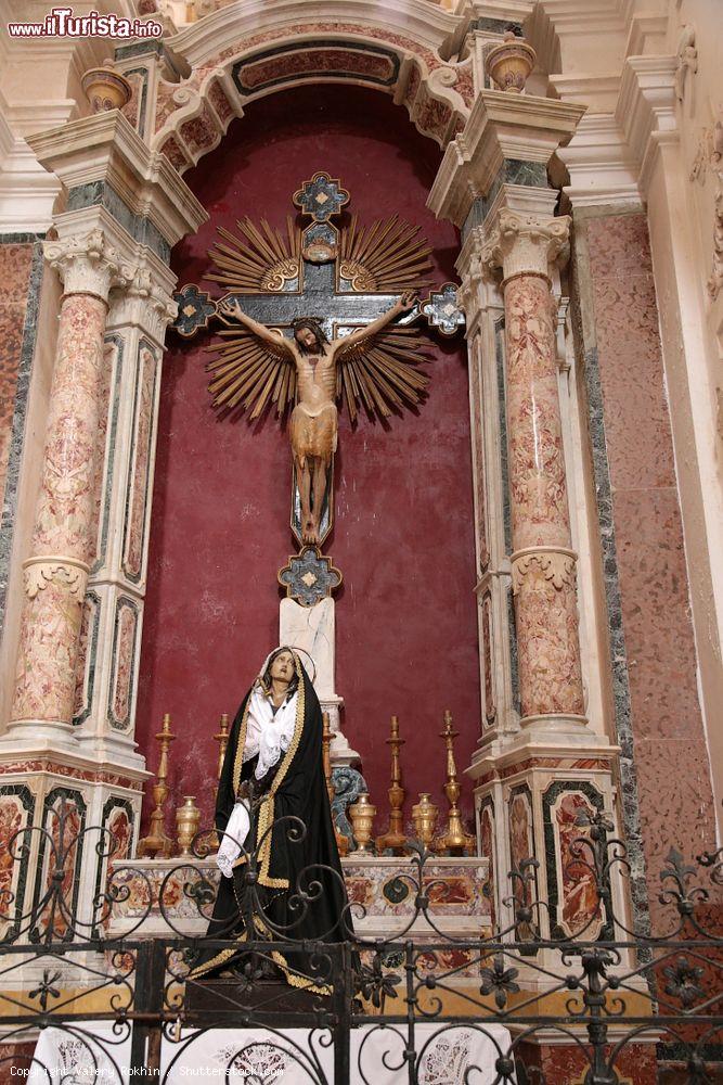 Immagine Interno della cattedrale di San Tommaso a Marsala, Sicilia: Gesù in croce e una statua nella nicchia di un altare - © Valery Rokhin / Shutterstock.com