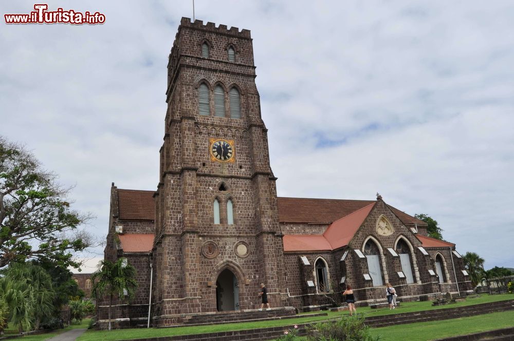 Immagine La chiesa cattolica di Basseterre, St. Kitts and Nevis, Indie Occidentali. Immerso nel verde, questo edificio di culto si presenta con una semplice facciata di mattoni su cui spicca l'orologio con sfondo nero.