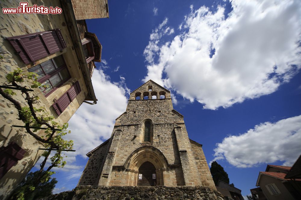 Immagine La chiesa di Beaulieu-sur-Dordogne (Francia) vista dal basso verso l'alto, in una giornata dal cielo azzurro e con le nuvole.