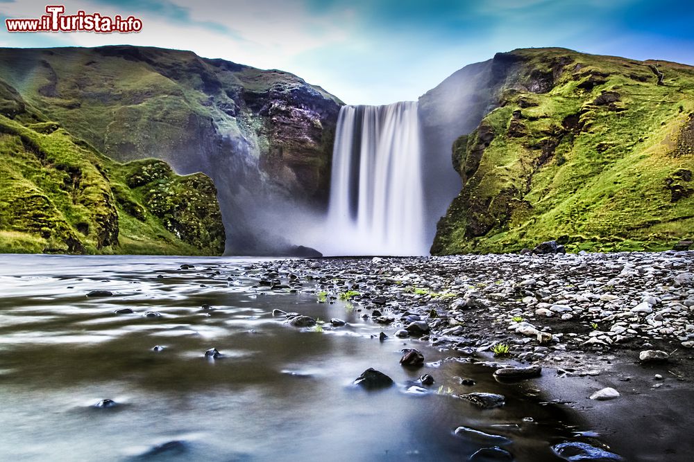 Immagine La famosa cascata di Skogafoss, Islanda, fotografata al crepuscolo. Secondo un'antica leggenda un vichingo stabilito nella zona nascose un forziere colmo di monete d'oro nella caverna che si trova dietro la cascata.