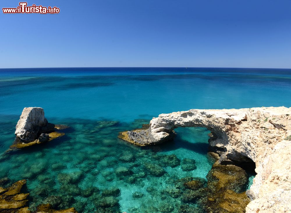 Immagine La Laguna Blu sull'isola di Cipro. Le acque cristalline di questa baia nella penisola di Akamas consentono di vedere il fondo del mare. In questa immagine, una bella veduta mattutina del ponte dell'amore, in roccia, nei pressi della spiaggia Cavo Greco.