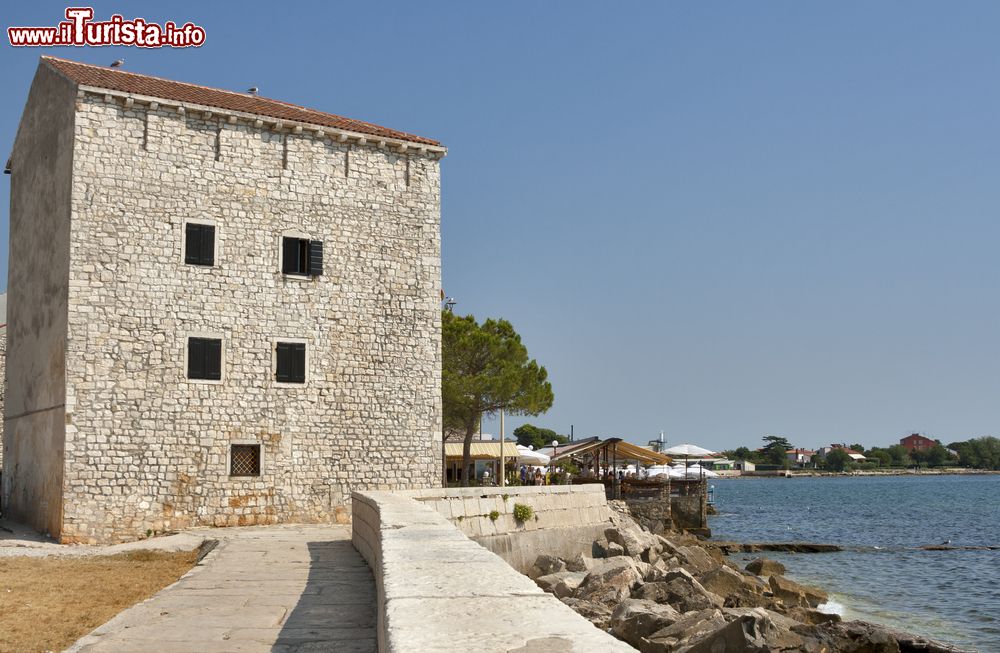 Immagine La passeggiata del lungomare di Umago (Croazia) e un'antica casa in pietra proprio in riva all'Adriatico.