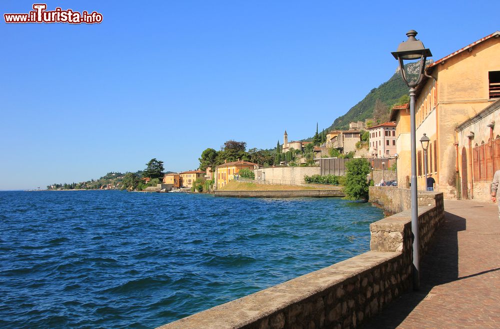 Immagine La passeggiata lungolago di Gargnano, Lombardia, Italia. A illuminare la stradina che si affaccia sul lago di Garda ci sono i lampioni.