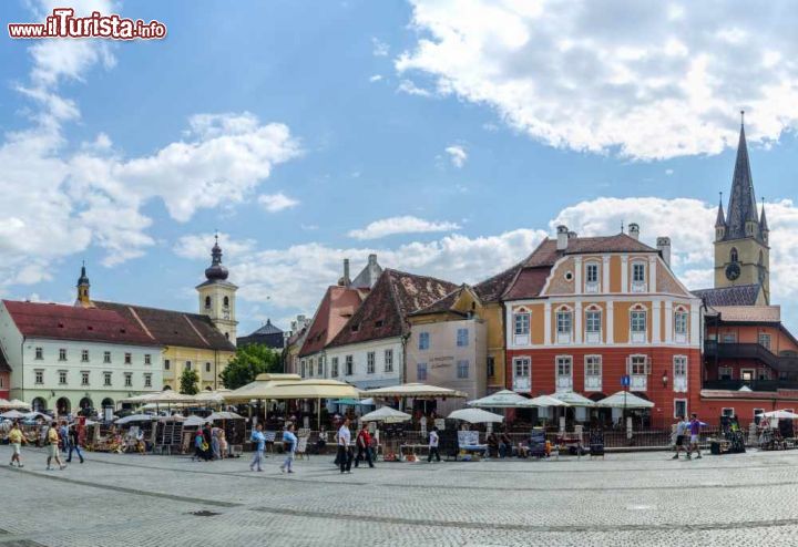 Immagine Turisti nella Piazza Piccola di Sibiu, Romania - Collegata alla Piazza Grande da alcuni stretti passaggi, "Piata Mica" (ovvero Piazza Piccola) è caratterizzata dalla curvatura del lato nord occidentale. Passando sotto ad un ponte metallico costruito nel 1859 si giunge alla strada che porta nella parte bassa di Sibiu. Su questo grazioso piazzale si affacciano alcuni degli edifici più belli della città medievale di Sibiu © pavel dudek / Shutterstock.com