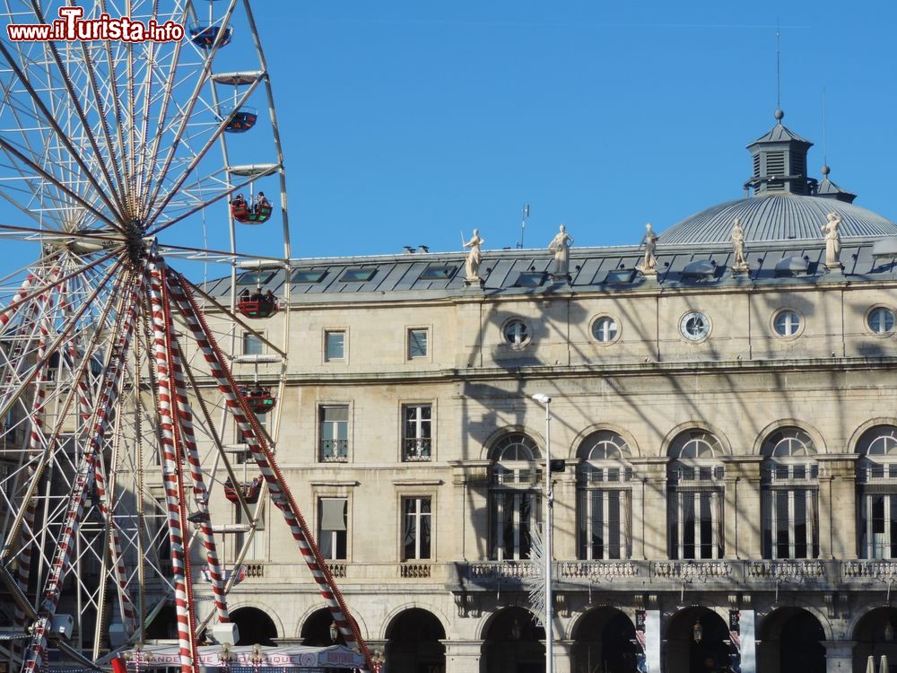 Immagine La ruota panoramica di un parco divertimenti a Bayonne, Francia, con il riflesso su un antico palazzo cittadino.