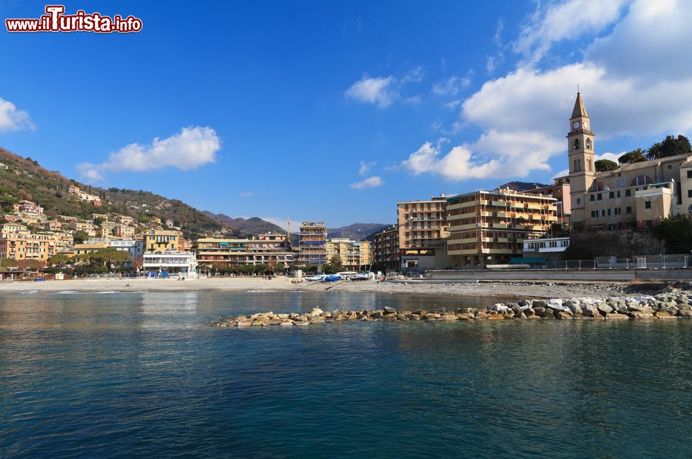 Immagine La spiaggia e la passeggiata di Recco, Genova, Liguria. La sabbia, interrotta da rocce e scogli, rende questa località una delle preferite dagli appassionati di mare e attività sportive.
