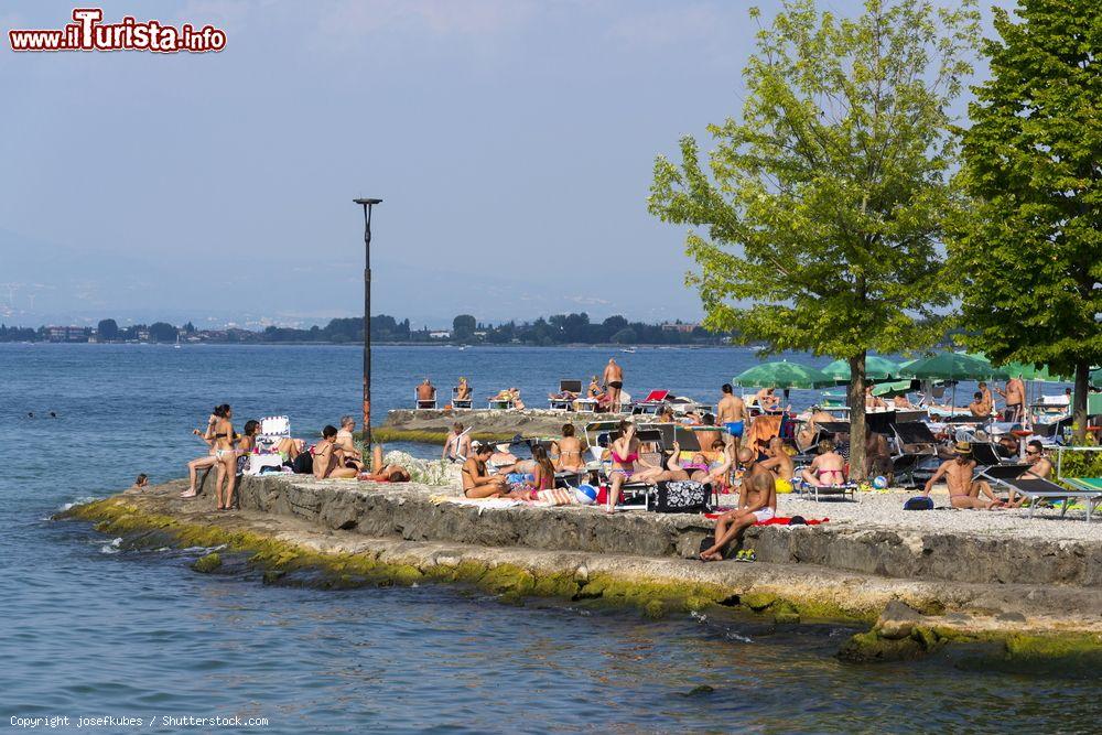 Immagine La spiaggia lungolago di Desenzano del Garda, Lombardia, con gente che prende il sole - © josefkubes / Shutterstock.com