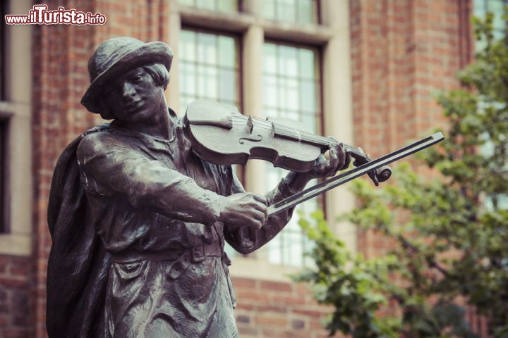 Immagine La statua del barcaiolo violinista nella città polacca di Torun. Secondo una leggenda, durante il periodo medievale, un barcaiolo portò fuori dalla città migliaia di rane che infestavano le mercanzie in deposito. Come ci riuscì? Suonando una dolce melodia con il suo violino. Proprio in suo onore venne eretta una statua nel lato sud ovest del Municipio, nel centro storico - © Curioso / Shutterstock.com