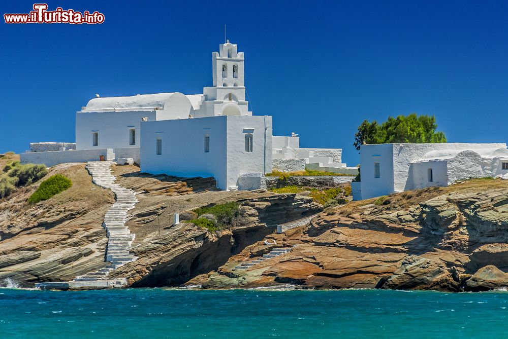 Immagine La veduta di una suggestiva chiesa a Sifnos, Grecia. A fare da contrasto all'intonaco bianco degli edifici è il blu del cielo e dell'acqua dell'Egeo.