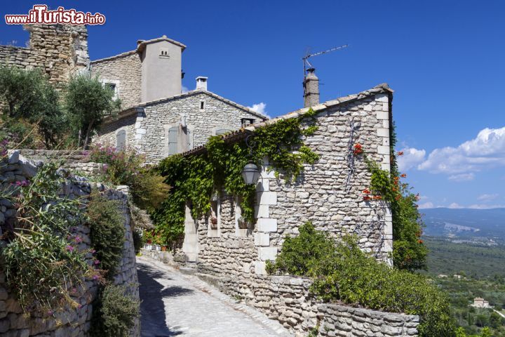 Immagine Visita al borgo di Gordes, Francia - Il fascino di questo antico villaggio francese muta con il variare dei colori della sua vegetazione e del cielo. Ogni stagione è buona per visitare Gordes: in estate è ottima occasione per trascorrere una serata al fresco mentre in inverno questo borgo arroccato in alto emerge dalla nebbia con le sue abitazioni in pietra illuminata dai raggi del sole. In primavera invece si ricopre di fiori profumati © Magdanatka / Shutterstock.com