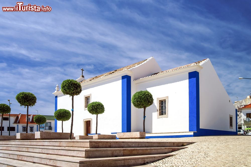 Immagine L'architettura lineare di una vecchia chiesa di Ericeira, Portogallo. Gli inserti color blu riprendono la tonalità del cielo che sovrasta questa località paradiso dei surfisti.