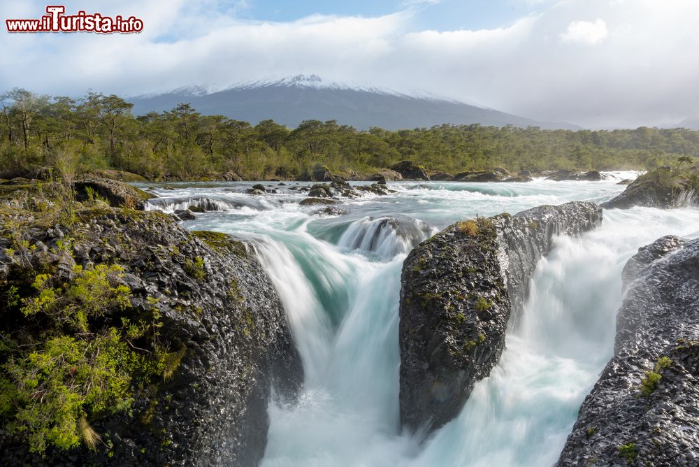 Immagine Le cascate Petrohue e il vulcano Osorno con la sua cima innevata nei pressi di Puerto Montt, Cile. Queste cascate fragorose offrono un panorama mozzafiato che ha come scenario il vulcano Osorno con i suoi 2652 metri di altezza.