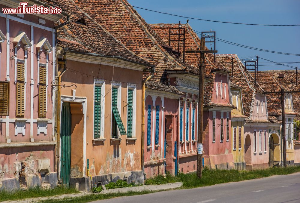 Immagine Le tipiche facciate delle abitazioni di Biertan, Transilvania, Romania. Intonaci dipinti e scuri delle finestre in legno e verniciati.