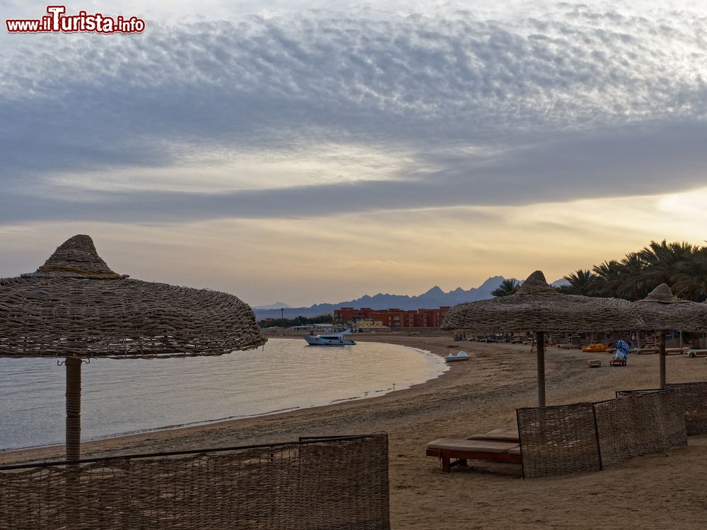 Immagine Lettini e ombrelloni di paglia sulla spiaggia di Soma Bay al tramonto. Siamo 40 km a sud di Hurghada, Egitto.